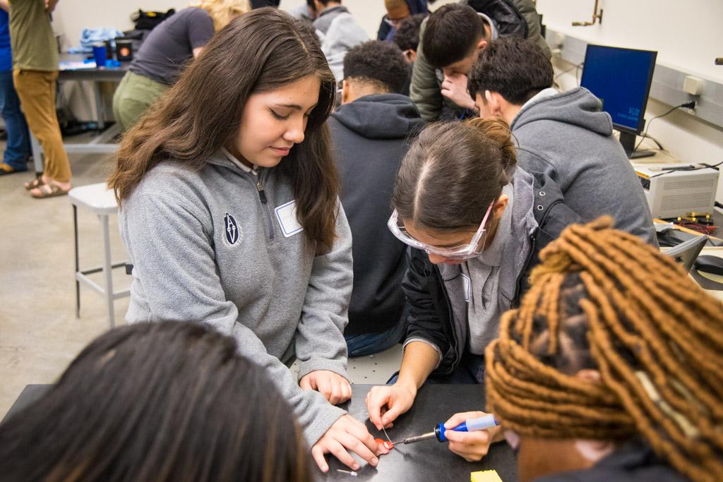 Image of students soldering a wire to a circuitboard